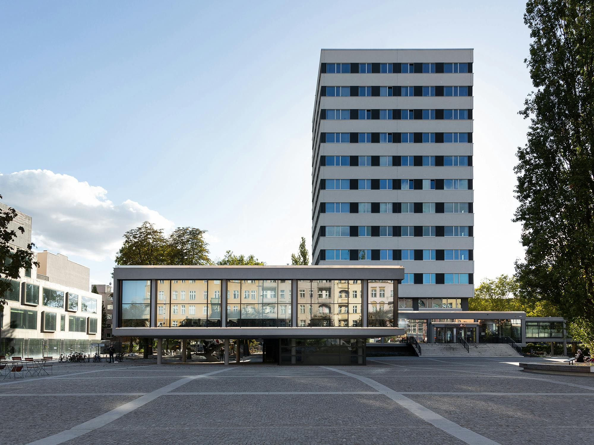 Horizontale Schwarz-Weiß-Gliederung der erneuerten Fassade mit dem ehemaligen BVV-Saal im Vordergrund
